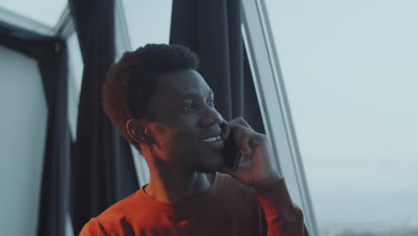 African-American-Man-Speaking-on-Phone-by-Window-in-Office